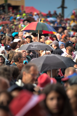 Nyon, Switzerland - 27 July 2019 : zoom on the crowd under the rain with umbrellas, a person is holding a colorful umbrella where it says " je veux du soleil", I want some sun"のeditorial素材