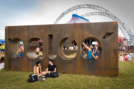 Nyon, Switzerland - 24 July 2019 :  general view of the festival area with festival iron sign with people chilling and sitting on the signのeditorial素材