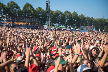 Nyon, Switzerland - 23 July 2019: Audience crowd cheering arms up in the air in front of concert of Canadian rock band from Quebec Les Cowboys Fringants at Paleo Festivalのeditorial素材