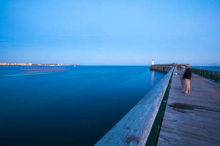 Entrance of Les Sables D'Olonne harbour taken from La Chaume, with it pier and lighthouse called Petite Jetee at sunset, Vendee, Franceの写真素材