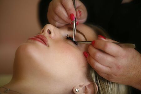 A young female is getting her eye lashes done