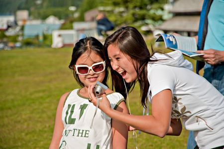 Two young Asian girls looking at their digital camera laughingの写真素材