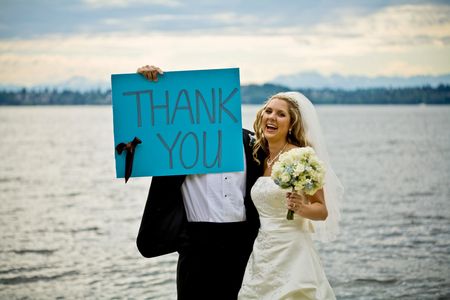 A newly wed couple holding up a thank you signの写真素材