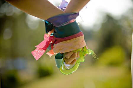 A pair of female hands wrapped with colorful ribbons holding to each otherの写真素材