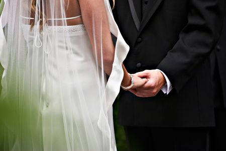 The bride and the groom was holding hands during their wedding ceremonyの写真素材