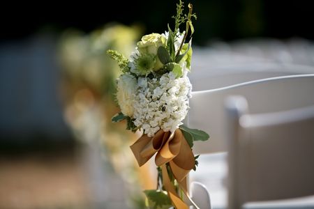 A close up view of a bouquet on a white chairの写真素材