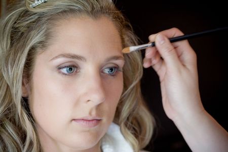 A bride is having her make up done by an artistの写真素材