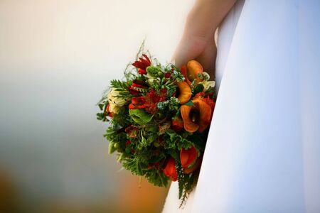 A bride's hand holding a beautiful bouquetの写真素材