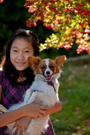 An Asian girl is playing with her dog at Luther Burbank parkの写真素材