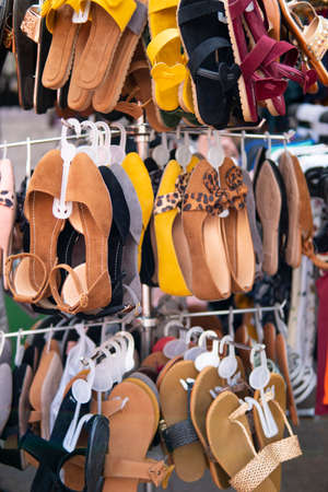 Close up of womenâs footwear shoes, sandals, hanging on display for sale at outdoor street market.の写真素材
