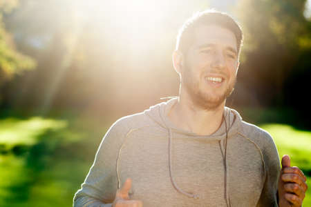 Guy running and laughing with sun lightの写真素材