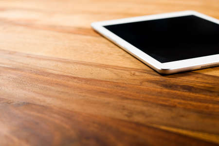 Tablet PC on dark wood tableの写真素材
