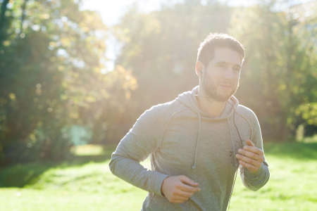Young man in park runningの写真素材