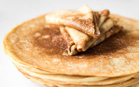 A stack of thin Russian pancakes and crepes folded triangle, close-up, isolatedの写真素材