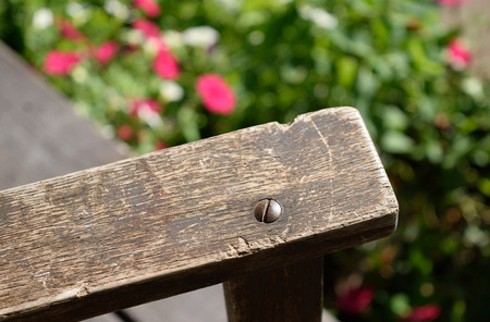 Close-up of Old Weathered Rocking Chair Arm with Flowers の写真素材