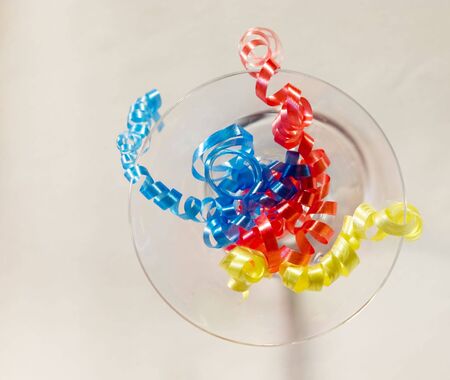 The multi-coloured streamers hanging with a glass of martini perfectly sets celebratory moodの写真素材