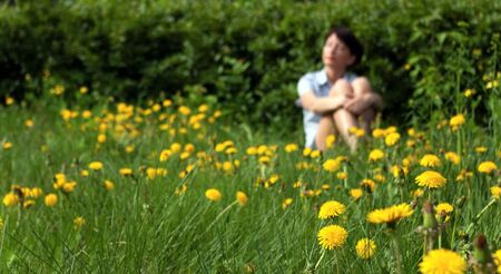 Young girl relaxing on a meadow dandelionの写真素材
