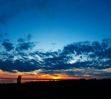 Beautiful cloudscape with sunset on a coast riverの写真素材