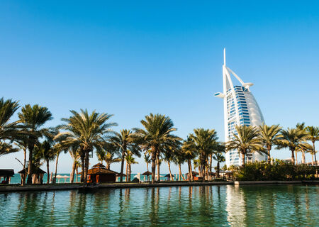DUBAI, UNITED ARAB EMIRATES - DECEMBER, 10, 2013  Beach with palms and view on seven stars luxury hotel Burj Al Arab  Tower of the Arabs  in Dubaiのeditorial素材