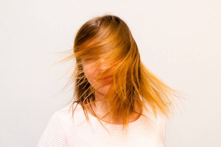 Young beautiful girl with red hair flyingの写真素材