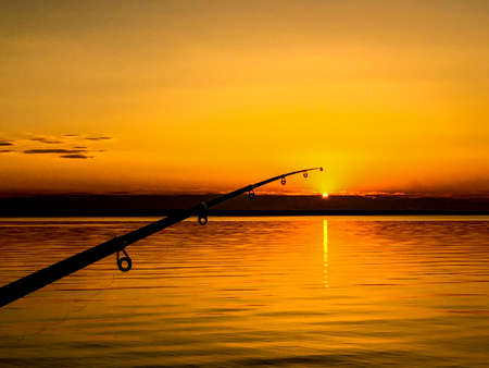 Fisherman fishing rod at sunsetの写真素材