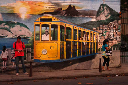 street art in a wall of Santa Teresa neighborhood, Rio de Janeiro, Brasil. this painting is about the old trolley car that still works in the area with a landscape of the city of Rio behindのeditorial素材