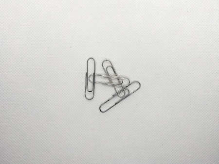 A bunch of paperclips over a white surface