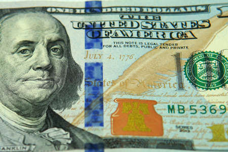 close up view of the middle part of a 100 dollar bill. Taken inside a studio under white soft...