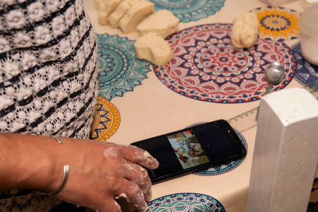 A young woman following a online video recipe for homemade scones