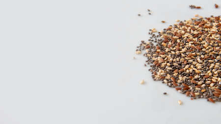 Close view of chia, flax and sesame seeds mix over a white background with copy spaceの写真素材