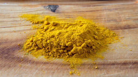 Close view of a bunch of curry powder on top of a wooden surfaceの写真素材