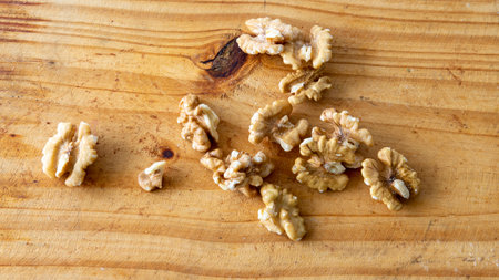 Top view of a bunch of shelled walnuts on top of a wooden table