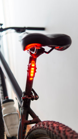 Close view of a red safety light attached to a black bicycleの写真素材