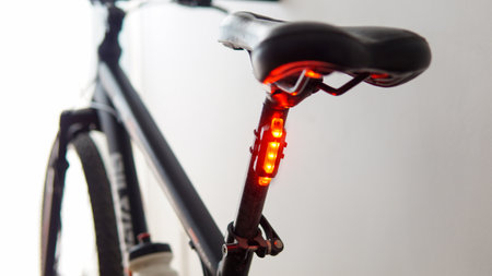 Close view of a red safety light attached to a black bicycleの写真素材
