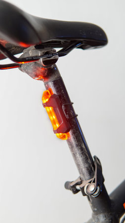 Close view of a red safety light attached to a black bicycleの写真素材