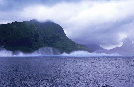 Waves crashing against mountain in Moorea, French Polynesia.の写真素材
