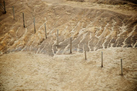 A fence across some rocky dunes at the beach