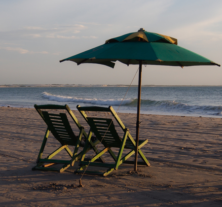 two deckchair and parasol in the beachの写真素材