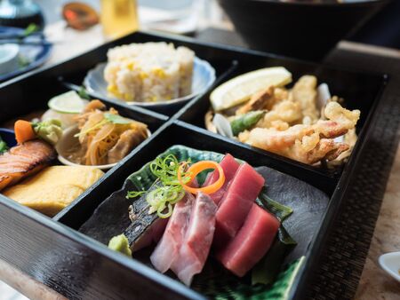 Japanese Bento box lunch with raw fish, rice, tempura and vegetablesの写真素材