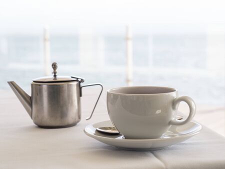 Metal silver teapot and white cupの写真素材