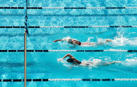 The swimmers competing at a high school meet strive for victoryの写真素材
