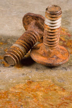 Old rusty bolts on a solid piece of slate stoneの写真素材