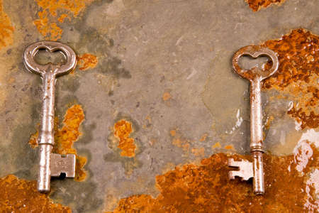 Old skeleton type keys on a solid slate stone foundationの写真素材