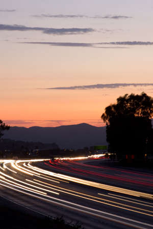 Rush hour traffic at twilight on a busy and fast moving freeway or highwayの写真素材