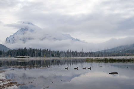 Beautiful Rocky Mountain lake in Alberta, Canada in autumn fall season and storm cloudsの写真素材