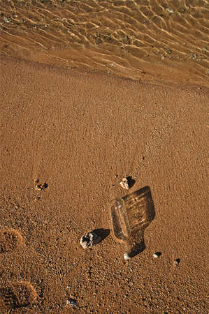 Tropical beach and surf with a washed up message bottleの写真素材