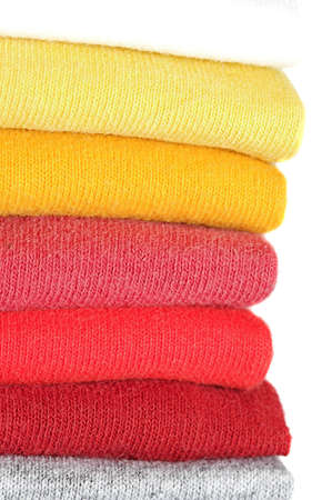 Stack of colored tee shirts on a shelfの写真素材