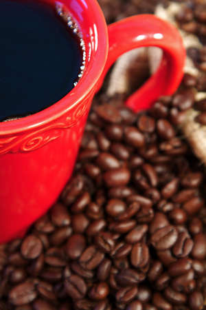 Coffee beans spilling from a burlap sack and fresh coffeeの写真素材