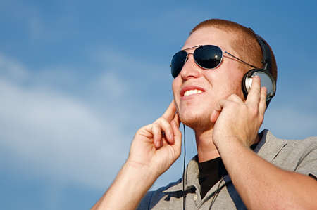 A cool young man listens to music on some headphonesの写真素材