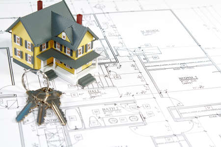 Residential home blueprints with a hand-made house model.
